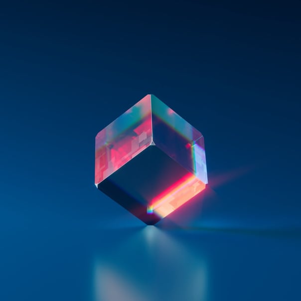 Crystal cube balanced on its edge, set against a blue background, with a subtle shadow beneath.